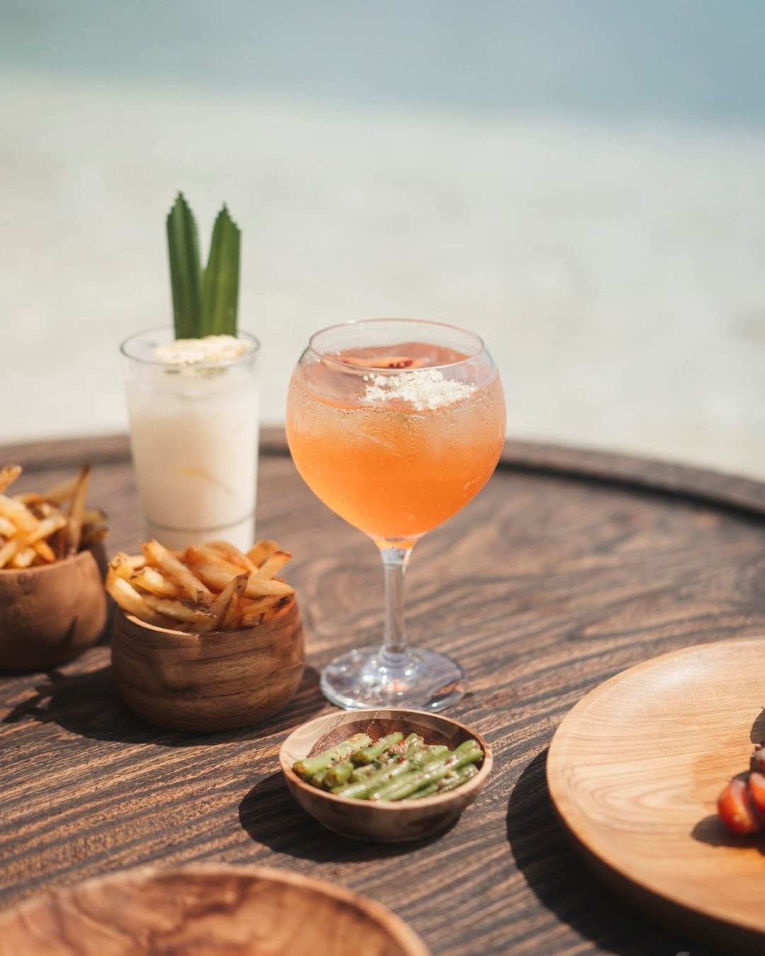 A glass of fresh drink and snacks on the table.